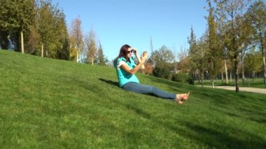 Bir kadın'ın bahçesinde parkta yalınayak oturur ve aynaya bakar