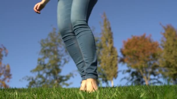 Çıplak ayakla çimlerde ayakla basma bir kadın — Stok video
