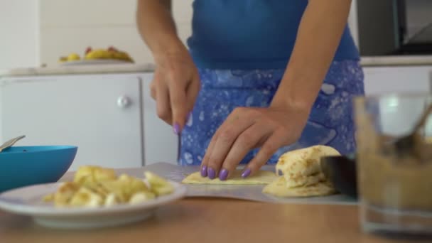 Žena v kuchyni škrty lilek na prkénku na stůl — Stock video
