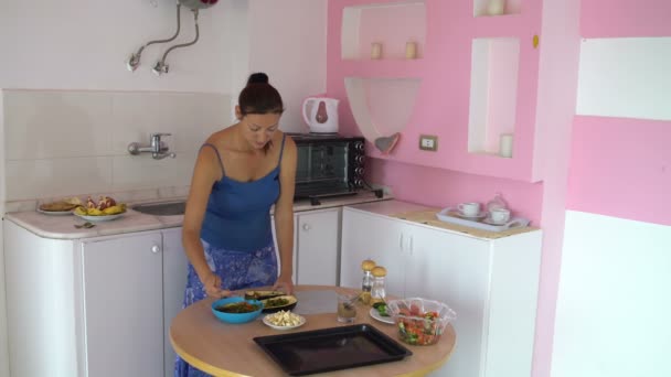 Mujer en la cocina pone verduras en berenjena — Vídeos de Stock