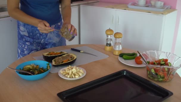 Vrouw uitstrijkjes saus met lepel op een aubergine — Stockvideo