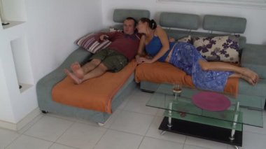 Bir erkek ve bir kadın kanepede televizyon izlerken yalan söylüyorsun. Kadın alır ve bırakır