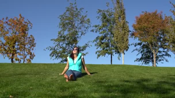 公園の芝生の上で裸足で座っている女性 — ストック動画
