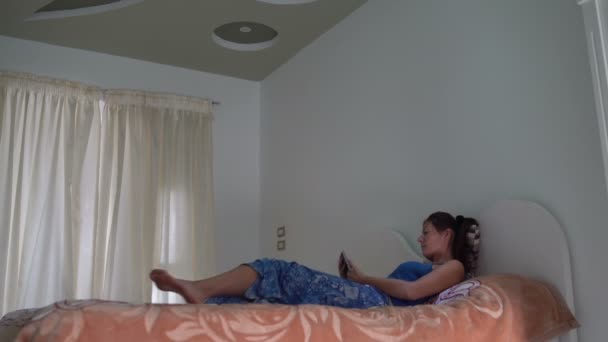 一名女子躺在沙发上 用的是平板电脑 — 图库视频影像