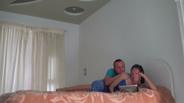 Žena a muž ležel na pohovce a použití počítače tablet pc — Stock video