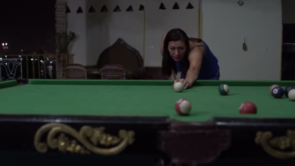 Uma mulher joga bilhar e marca uma bola de bilhar em um bolso — Vídeo de Stock