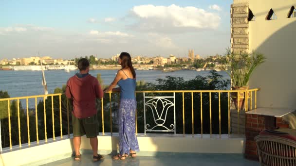 Uma mulher e um homem ficam no terraço e admiram a paisagem. Mulher sai — Vídeo de Stock