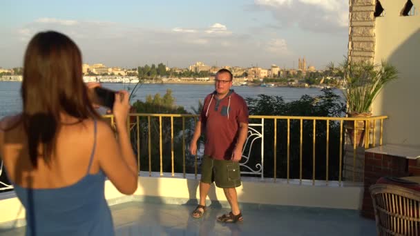 Uma mulher fotografa em um smartphone um homem em um salto — Vídeo de Stock