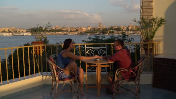 Un homme et une femme sont assis sur la terrasse. Femme éteint une cigarette et part — Video