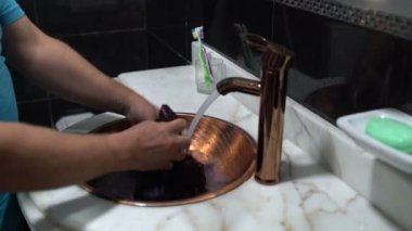 Adam bir ceket banyodaki lavaboda yıkar