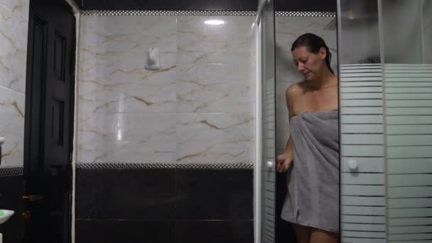 Mujer con una toalla saliendo de la cabina de ducha — Vídeos de Stock