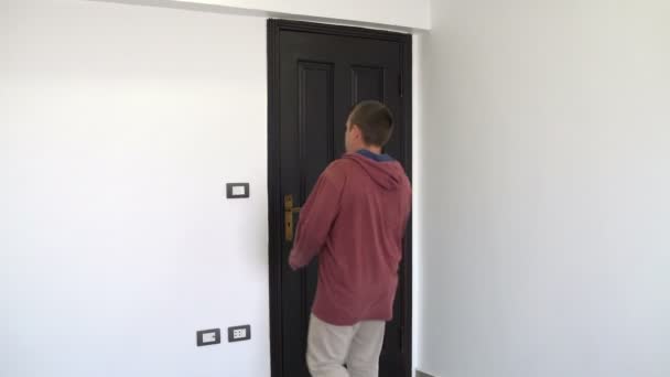 Homem apaga a luz abre a porta e sai da sala — Vídeo de Stock