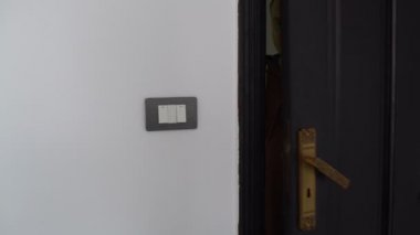 Adam kapıyı açar ışığı açar ve oda girer
