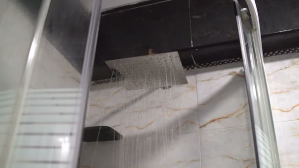 Die Tür zur Duschkabine öffnen. Wasser fließt aus der Dusche im Badezimmer — Stockvideo