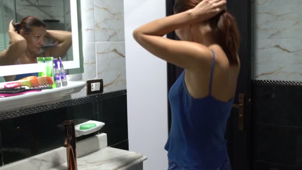 Žena při pohledu do zrcadla, přicházející z koupelny a dveře — Stock video