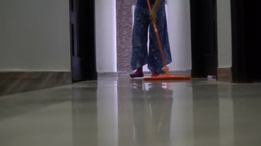 Koridorda bir paspas ile zemin bir kadın yıkar