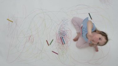 Kız el sallıyor. Boyalı zeminin arka planına merhaba diyor.