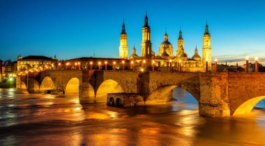 Zaragoza şehir, İspanya, görüntülemek Ebro Nehri'nin Ortaçağ taş Köprüsü Puente del Piedra ve katedral Yerebatan del Pilar gün batımında