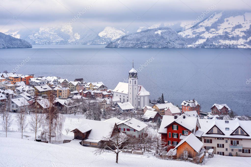Beckenried village on Lake Lucerne, swiss Alps mountains, Switzerland, covered with white snow in winter time