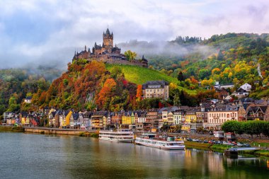 Cochem, Almanya, güzel tarihi kent romantik Moselle Nehri, sonbahar renk bir tepe üzerinde Reichsburg kale şehir manzaralı