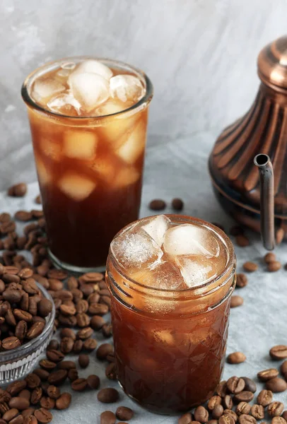 Ice Coffee in Tall Glass with Bean on Rustic Grey Background