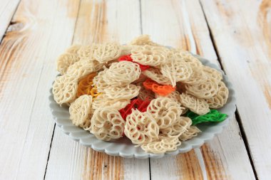 Renkli Kerupuk Kembang Mawar Mentah veya Seramik Tabakta Çiğ Gül Krakerleri 