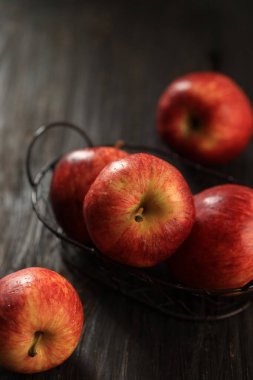 Siyah Rustik Masa 'nın üstündeki tel sepetin üzerine Kırmızı Elmayı Kapat 