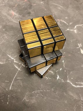 Rubik küpü 3 x 3 erkek eller, yakın çekim, üstten görünüm, mermer arka plan.