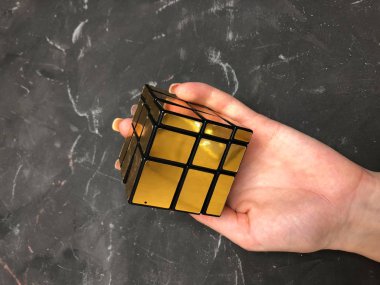 Rubik küpü 3 x 3 erkek eller, yakın çekim, üstten görünüm, mermer arka plan.