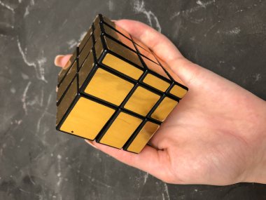 Rubik küpü 3 x 3 erkek eller, yakın çekim, üstten görünüm, mermer arka plan.