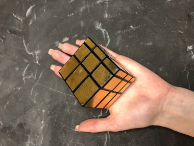 Rubik küpü 3 x 3 erkek eller, yakın çekim, üstten görünüm, mermer arka plan.