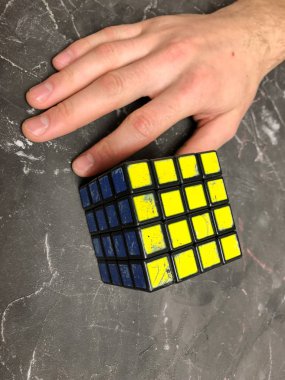 Rubik küpü 3 x 3 erkek eller, yakın çekim, üstten görünüm, mermer arka plan.