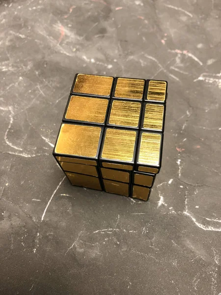 Rubik küpü 3 x 3 erkek eller, yakın çekim, üstten görünüm, mermer arka plan.