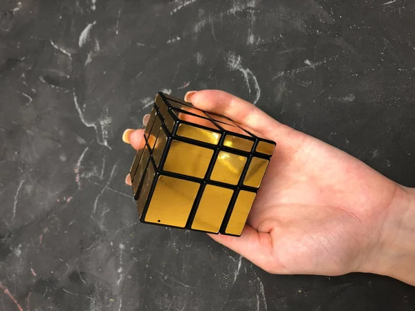 Rubik küpü 3 x 3 erkek eller, yakın çekim, üstten görünüm, mermer arka plan.
