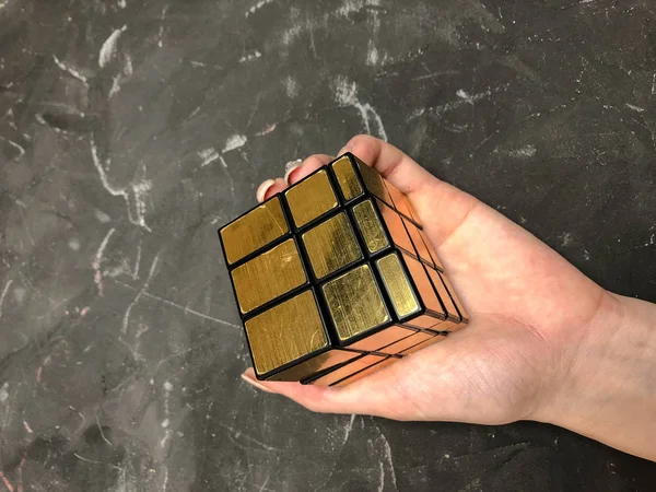 Rubik küpü 3 x 3 erkek eller, yakın çekim, üstten görünüm, mermer arka plan.