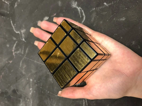 Rubik küpü 3 x 3 erkek eller, yakın çekim, üstten görünüm, mermer arka plan.