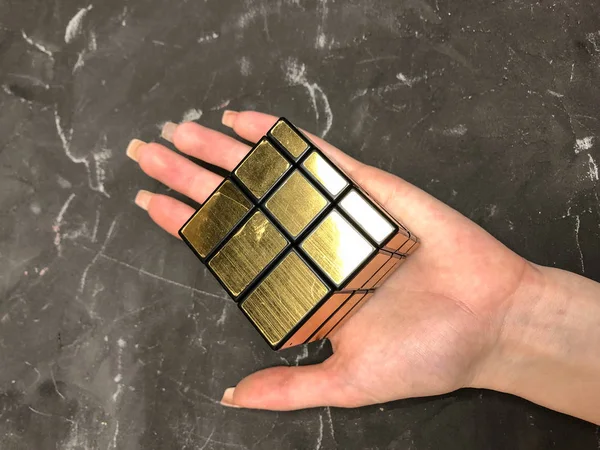 Rubik küpü 3 x 3 erkek eller, yakın çekim, üstten görünüm, mermer arka plan.