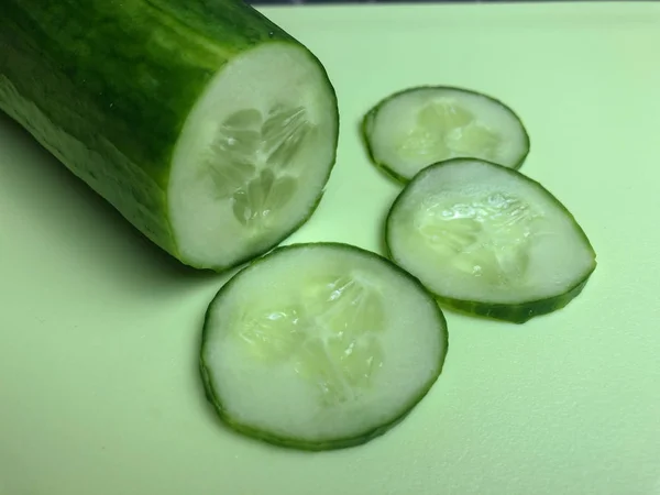 Cucumber sliced on the cutting board, salad ingredient, fresh cucumbers on a table.