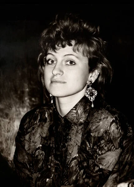 80 'li yılların modasına uygun giyinmiş abartılı güzellikteki genç bir kızın klasik yarı dönüştürülmüş portresi. 1987 'den geriye dönük fotoğraf.