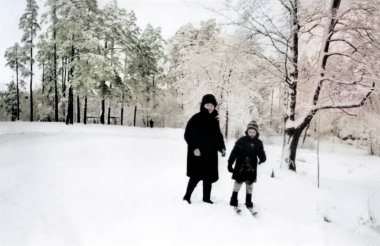 Mutlu anne ve oğulun klasik portresi. Anne oğluna kayak yapmayı öğretiyor. Karlı kış. Retro fotoğraf 1971. SSCB.