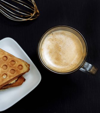 Siyah arka planda Viyana Waffle 'lı kahve.