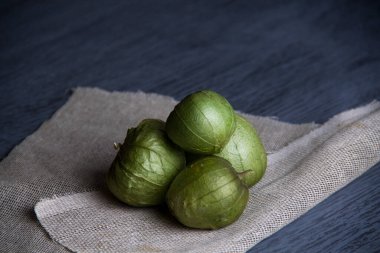 Ahşap masada çiğ yeşil domates.