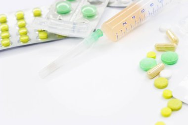 Pembe arka planda vitamin hapları ve beyaz çiçekli tıbbi konsept. Düz yatış, üst görünüm.