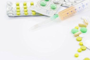 Pembe arka planda vitamin hapları ve beyaz çiçekli tıbbi konsept. Düz yatış, üst görünüm.