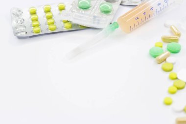 Pembe arka planda vitamin hapları ve beyaz çiçekli tıbbi konsept. Düz yatış, üst görünüm.