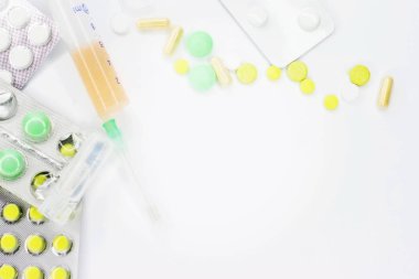 Pembe arka planda vitamin hapları ve beyaz çiçekli tıbbi konsept. Düz yatış, üst görünüm.