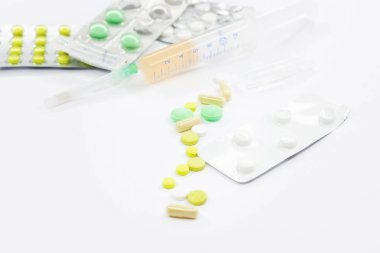 Pembe arka planda vitamin hapları ve beyaz çiçekli tıbbi konsept. Düz yatış, üst görünüm.