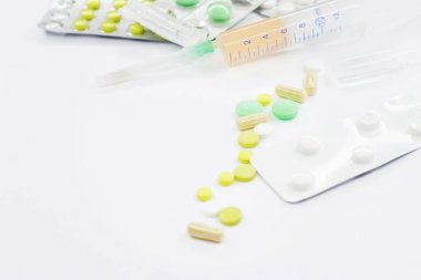 Pembe arka planda vitamin hapları ve beyaz çiçekli tıbbi konsept. Düz yatış, üst görünüm.