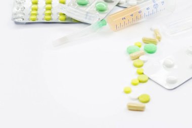 Pembe arka planda vitamin hapları ve beyaz çiçekli tıbbi konsept. Düz yatış, üst görünüm.