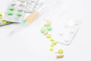 Pembe arka planda vitamin hapları ve beyaz çiçekli tıbbi konsept. Düz yatış, üst görünüm.